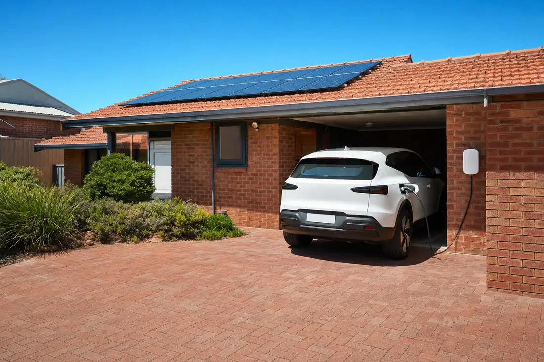 Electric car charging from a wall-mounted home EV charger under a Perth home with rooftop solar panels