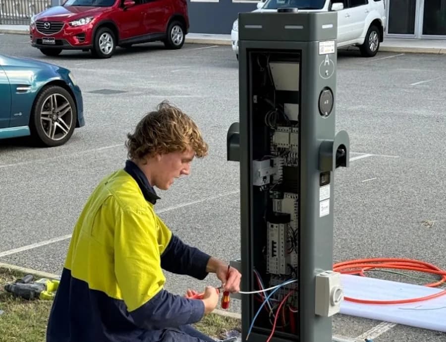 Electrician checking the wiring inside a public EV charger in Perth