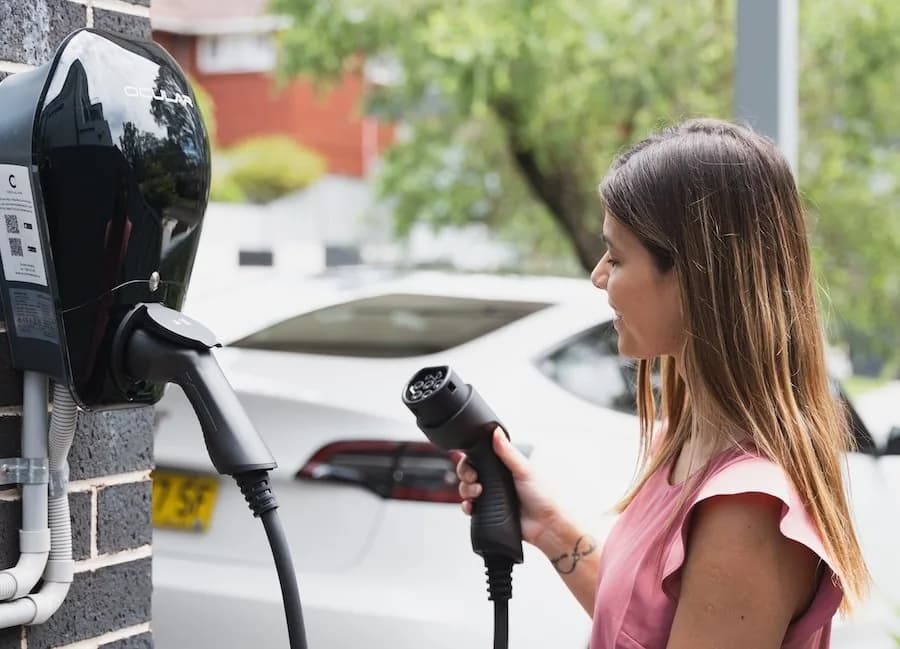 Woman plugging in home EV charger in Perth, Western Australia