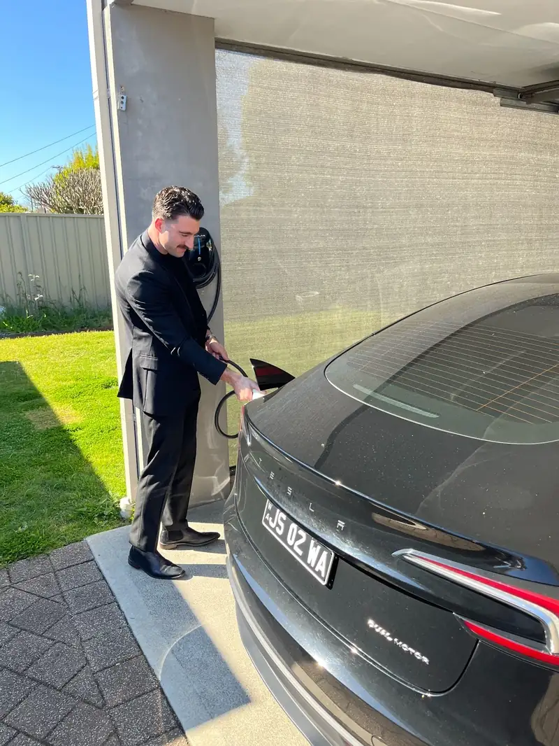 Homeowner plugging his Tesla Model 3 into his home EV charger in Morley