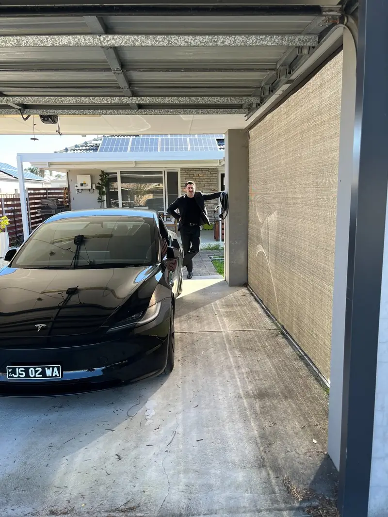 Tesla Model 3 under a carport with a wall-mounted EV charger in Morley, Perth