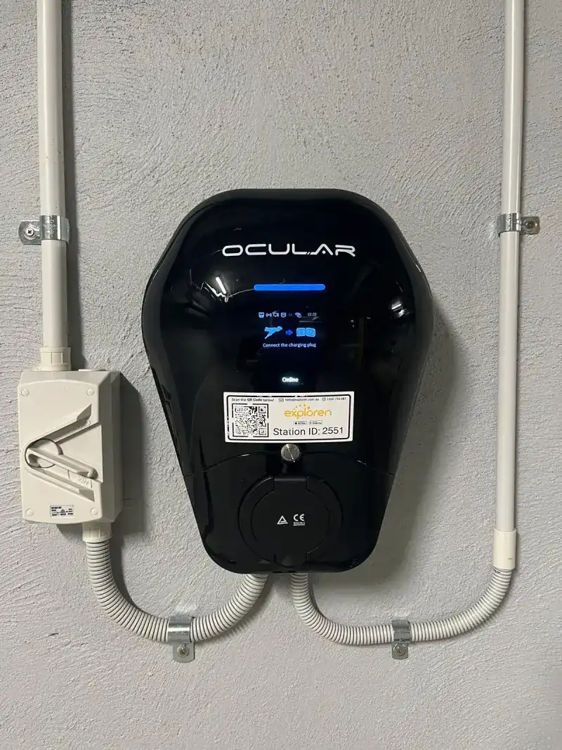 Ocular IQ Wallbox charger with an Exploren station label in a resident's car bay at Revue Apartments, Dalkeith