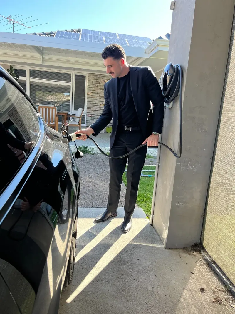 Morley homeowner beside his wall-mounted home EV charger in the driveway, Perth