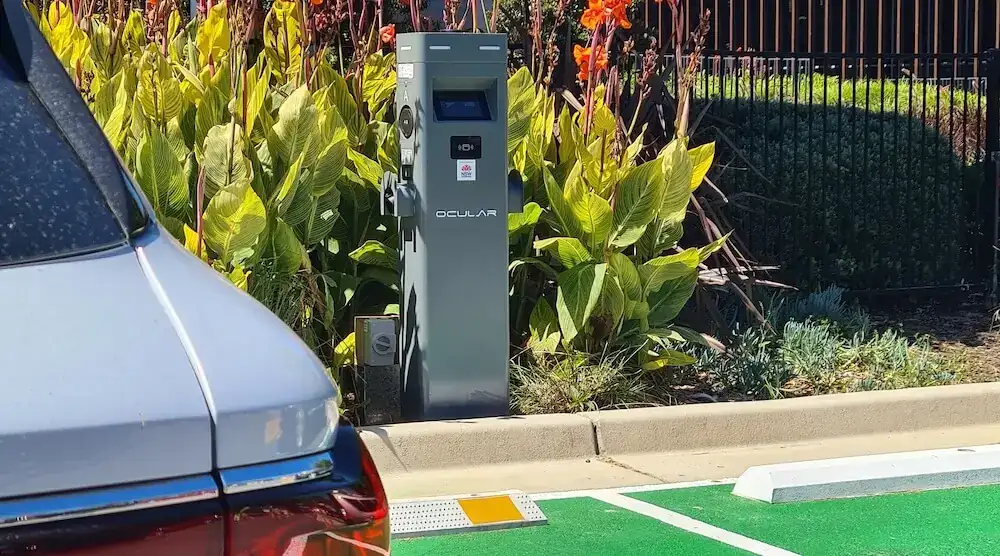 Floor-mounted EV charger beside a marked charging bay in a car park